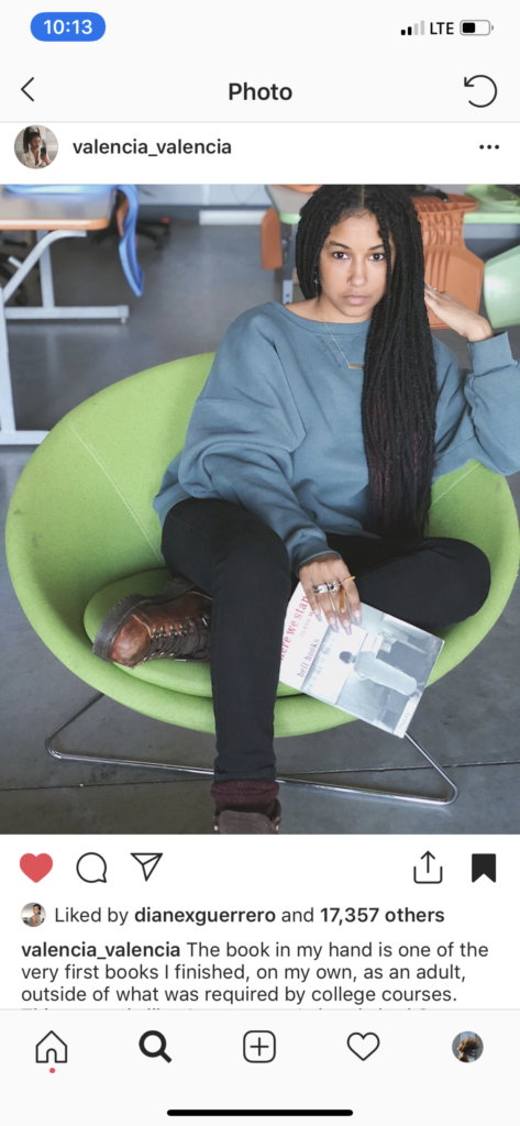 Screenshot of Valencia De'La Clay on Instgram sitting in a green chair with a book in her hand.