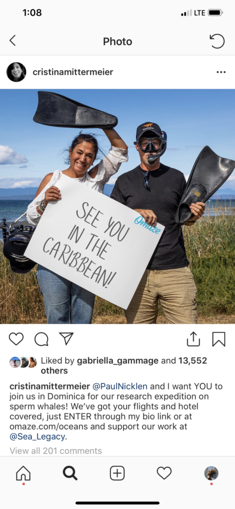 Screenshot of Cristina and Paul Nicklen on Instagram holding a sign that says "see you in the Caribbean!